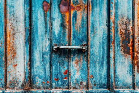 Téléchargez les photos : Ancienne poignée de porte de garage en métal, surface métallique usée comme texture grunge et fond avec des pièces mangées de rouille, couleur vibrante - en image libre de droit