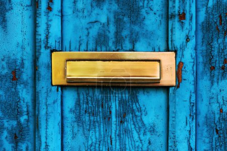 Photo for Old letterbox or mailbox slot on worn wooden blue door with paint peeling off - Royalty Free Image