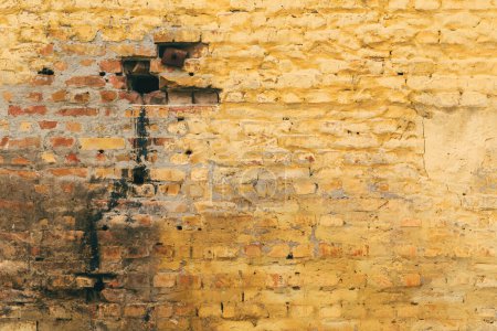 Téléchargez les photos : Vieux fond de mur de brique jaune fissuré et sale avec une texture et un motif usés uniques de la surface comme toile de fond abstraite pour la conception - en image libre de droit