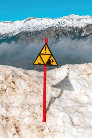 Téléchargez les photos : Panneau d'avertissement sur la falaise sur la montagne enneigée dans le parc national du Triglav en Slovénie, mise au point sélective - en image libre de droit