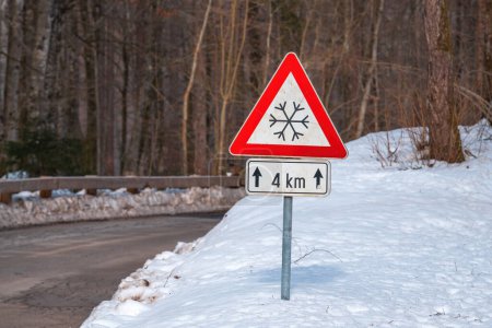 Téléchargez les photos : Méfiez-vous du panneau d'avertissement triangulaire de glace ou de neige près de la route en hiver, foyer sélectif - en image libre de droit