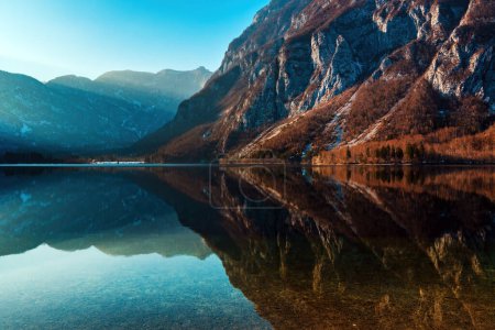 Téléchargez les photos : Beau paysage pittoresque, colline de montagne rocheuse reflétant la surface du lac clair Bohinj en Slovénie en hiver. Pas de peuple. - en image libre de droit