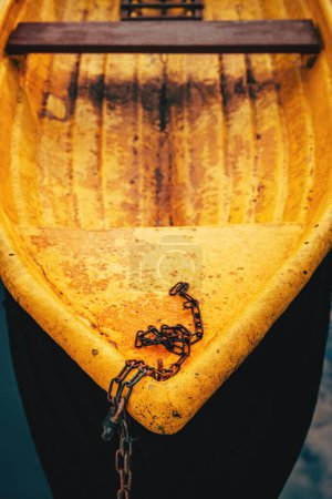 Téléchargez les photos : Vieux bateau de pêche en plastique jaune dériveur avec chaîne rouillée, mise au point sélective avec une faible profondeur de champ - en image libre de droit