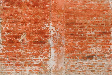 Foto de Pared de ladrillo viejo con pintura roja pelada y mortero viejo resistido como fondo con textura y patrón únicos, fondo abstracto grunge - Imagen libre de derechos