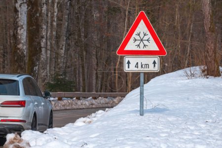 Photo for Beware of Ice or snow triangular warning sign with supplementary plate by the road in winter, selective focus - Royalty Free Image