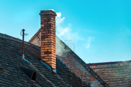 Photo for Smoke from the chimney of an old house with copy space - Royalty Free Image