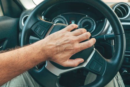 Photo for Angry and annoyed driver honking the car horn by pushing the button on steering wheel, pov image with selective focus - Royalty Free Image