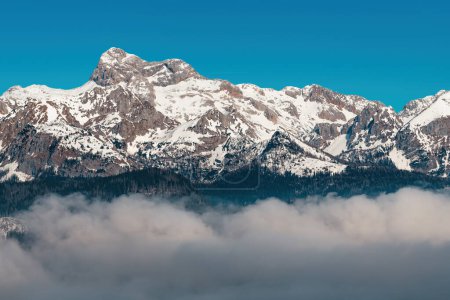Téléchargez les photos : Montagne Triglav, haut sommet des Alpes juliennes sloveniennes en hiver, au-dessus du brouillard du lac Bohinj en février matin - en image libre de droit