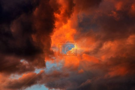 Téléchargez les photos : Rayons de soleil rayonnant à travers des nuages humides au ciel dramatique au coucher du soleil d'été, vue à faible angle - en image libre de droit
