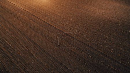 Photo for Aerial shot of tilled agricultural field prepared for sowing season, drone pov high angle view - Royalty Free Image