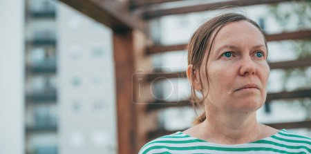 Photo for Headshot portrait of serious female person with small ponytail hairstyle looking into distance, selective focus - Royalty Free Image