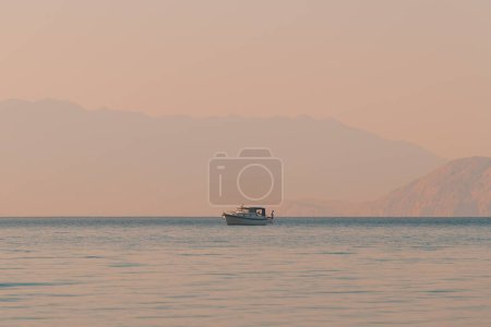 Téléchargez les photos : Pêcheur méconnaissable pêchant du bateau à la mer Adriatique le matin d'été, accent sélectif - en image libre de droit
