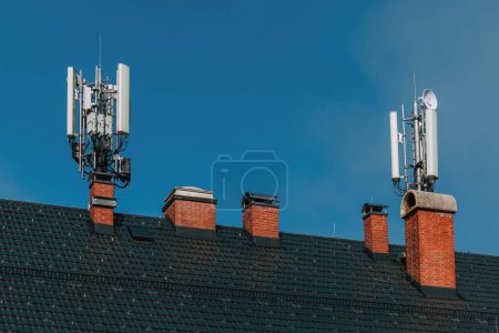 Téléchargez les photos : Station de base de téléphonie mobile et antenne de répéteur de signal sur le toit du bâtiment, équipement de technologie de télécommunication, foyer sélectif - en image libre de droit