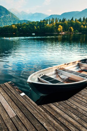 Téléchargez les photos : Dériveur flottant amarré à une jetée en bois au lac Bohinj en Slovénie, mise au point sélective - en image libre de droit
