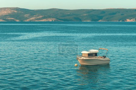 Téléchargez les photos : Bateau de pêche flottant sur l'eau près du rivage de la mer Adriatique dans la baie de Kvarner, foyer sélectif - en image libre de droit