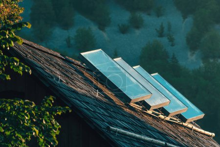 Foto de Viejos paneles solares de calentamiento de agua en la azotea de la casa en el campo alpino, enfoque selectivo - Imagen libre de derechos