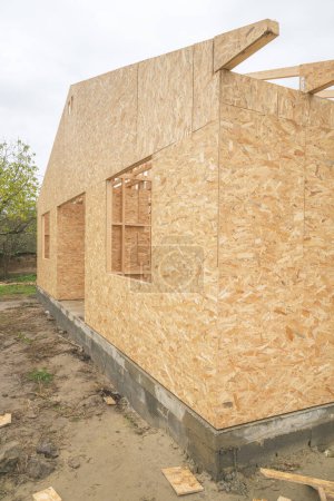 Foto de Sitio de construcción de casas de madera prefabricadas, vigas de madera y tableros de virutas de madera, enfoque selectivo - Imagen libre de derechos