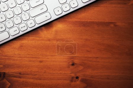 Téléchargez les photos : Clavier d'ordinateur personnel métallique blanc moderne sur bureau marron, vue de dessus avec espace de copie - en image libre de droit