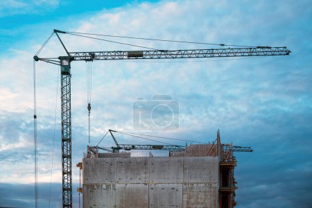 Photo for Tall prefabricated residential building construction site with old crane, selective focus - Royalty Free Image