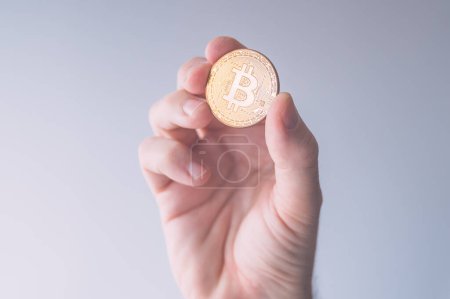 Photo for Cryptocurrency trader holding bitcoin BTC coin, business finance and economy concept with selective focus - Royalty Free Image