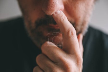 Téléchargez les photos : Gros plan du doigt mâle piquant le nez, mise au point sélective - en image libre de droit