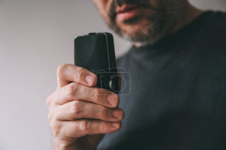 Téléchargez les photos : Homme tenant un appareil d'enregistrement vocal, mise au point sélective - en image libre de droit