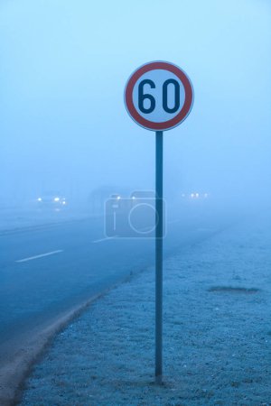 Photo for Speed limit traffic sign in foggy winter morning, selective focus - Royalty Free Image