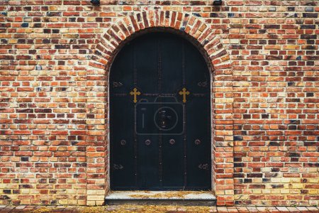 Téléchargez les photos : Porte d'entrée de l'église orthodoxe serbe avec décoration d'ornement vintage entourée d'un mur de briques clinker avec espace de copie - en image libre de droit