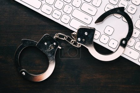 Photo for High tech IT cyber crime arrest concept, image of police handcuffs over computer keyboard, selective focus - Royalty Free Image