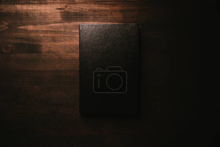 Photo for Black leather hardcover notebook mockup on wooden desk, top view - Royalty Free Image