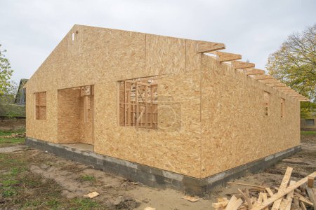 Téléchargez les photos : Construction préfabriquée de maisons en bois, solives à poutres et panneaux de copeaux de bois, mise au point sélective - en image libre de droit