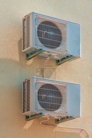Téléchargez les photos : Deux unités extérieures de climatisation montées sur le mur du bâtiment résidentiel en été - en image libre de droit