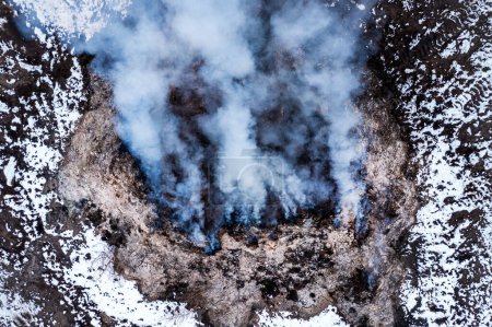 Téléchargez les photos : Brûlage de tas de fumier à la ferme, pollution et contamination de l'air, tir aérien depuis le point de vue du drone, vue en angle élevé - en image libre de droit