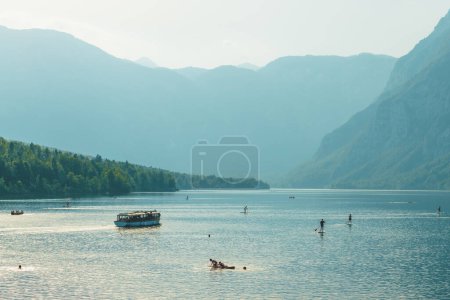 Téléchargez les photos : Après-midi sports nautiques et activités récréatives sur le lac Bohinj lors d'une journée d'été animée, accent sélectif - en image libre de droit