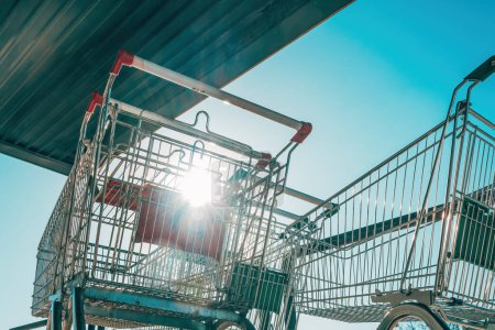 Photo for Sun shining through shopping cart trolley bars on a sunny day, selective focus - Royalty Free Image