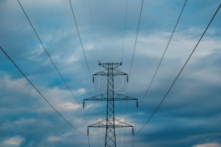 Foto de Pilón de electricidad con cables de línea eléctrica aérea contra el cielo nublado, vista de ángulo bajo - Imagen libre de derechos