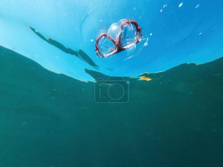 Téléchargez les photos : Plan sous-marin de masque de plongée flottant dans l'eau de l'océan, mise au point sélective - en image libre de droit