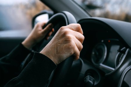 Téléchargez les photos : Blanc mains féminines tenant volant de voiture tout en conduisant à travers le paysage rural, foyer sélectif - en image libre de droit
