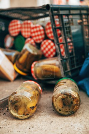 Foto de Pepinos encurtidos caseros caducados en frasco tirados a la basura, enfoque selectivo - Imagen libre de derechos