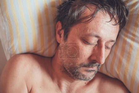 Foto de Vista superior del hombre caucásico adulto durmiendo en la cama, enfoque selectivo - Imagen libre de derechos