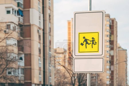 Photo for Children crossing in proximity of school traffic sign a warning and advising road users to drive extra slowly, selective focus - Royalty Free Image