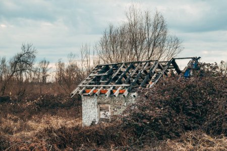 Téléchargez les photos : Maison abandonnée après incendie criminel dans le paysage rural par temps froid d'automne, accent sélectif - en image libre de droit