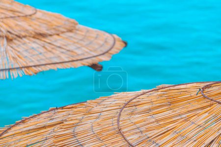 Téléchargez les photos : Palapa roseau parasols de plage au bord de la mer, accent sélectif - en image libre de droit