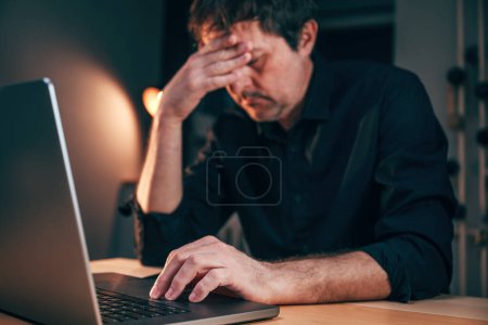 Photo for Common laptop malfunction problem giving a headache to a businessman while working overtime, selective focus - Royalty Free Image