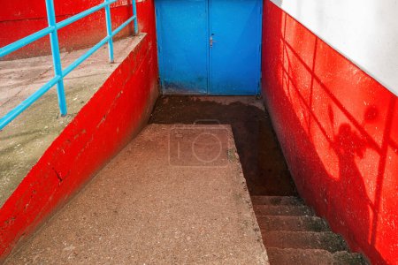 Téléchargez les photos : Porte métallique bleue comme entrée dans un sous-sol de bâtiment, foyer sélectif - en image libre de droit