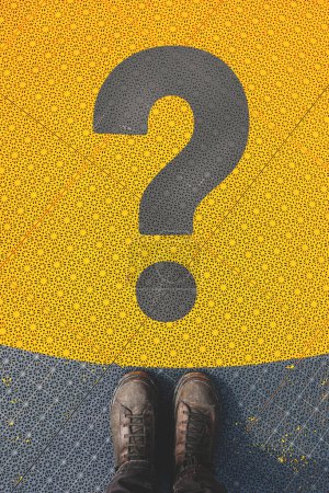 Questioning and reflective personality concept, man standing over large question mark symbol on non slip plastic flooring, top view