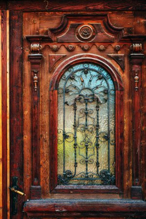 Foto de Antigua puerta de madera vintage con decoración tallada y detalles de hierro forjado, enfoque selectivo - Imagen libre de derechos