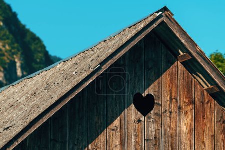 Herzförmiges Taubenloch auf einem hölzernen Bauernschuppen, Detail aus der Region Bohinj in Slowenien, selektiver Fokus