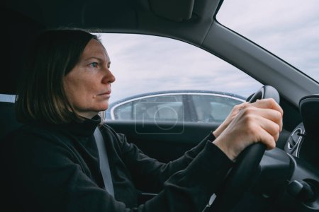 Foto de Caucásico manos femeninas sosteniendo el volante del coche mientras conduce a través del paisaje rural, enfoque selectivo - Imagen libre de derechos