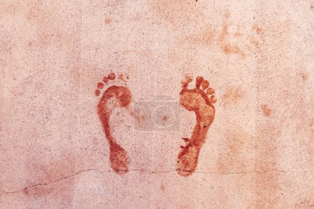 Téléchargez les photos : Empreinte humide des pieds mâles sur la surface du sol en béton, vue de dessus - en image libre de droit